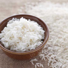 cooked rice in a small bowl, with dried rice scattered around