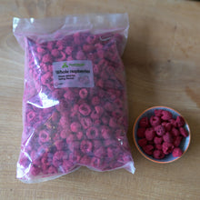 a large bag of freeze dried whole raspberries, next to a small bowl of freeze dried raspberries